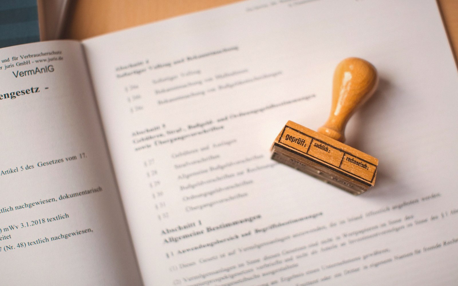 A wooden rubber stamp resting on an open German legal document